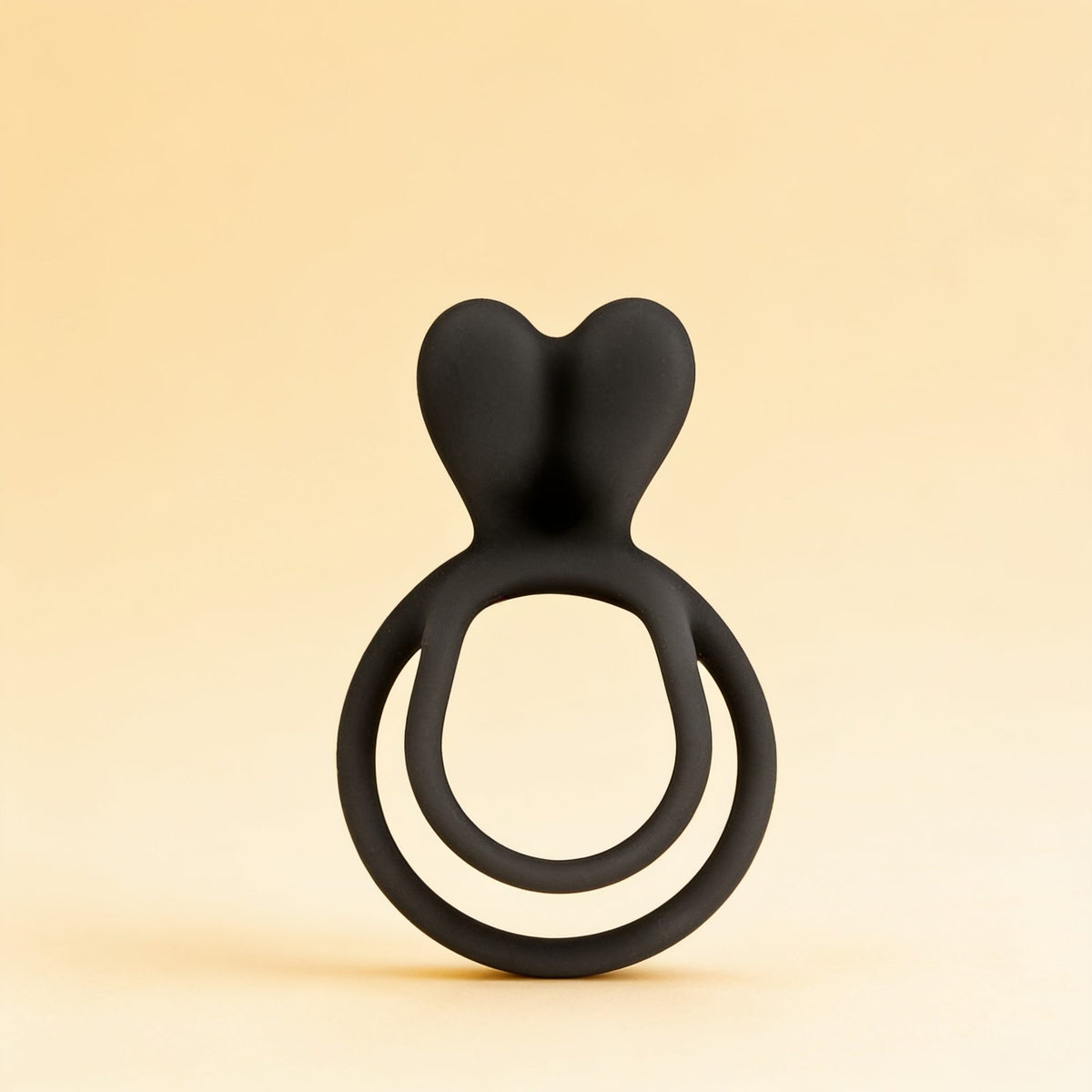 Anneau double cockring noir — packshot studio sur fond crème