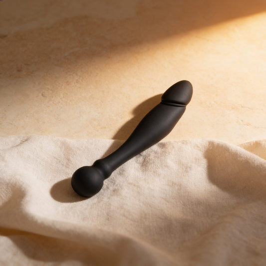 Dildo stimulant double flexible Ohmama 18 cm — posé sur du lin drapé, lumière chaude éditoriale