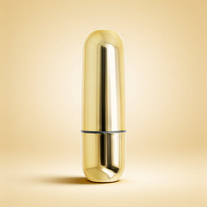 Mini balle vibrante dorée — packshot studio sur fond crème