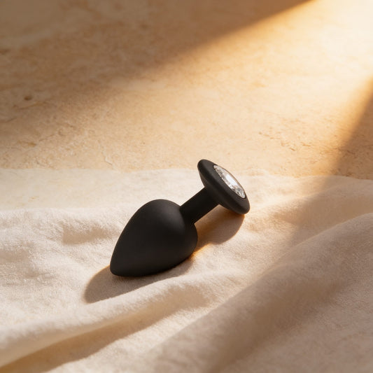 My Silicone Secret Plug Large noir — posé sur du lin drapé, lumière chaude éditoriale