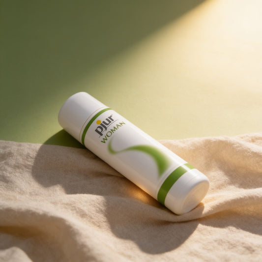 Lubrifiant pjur Woman Aloe 100 ml — posé sur du lin drapé, lumière chaude