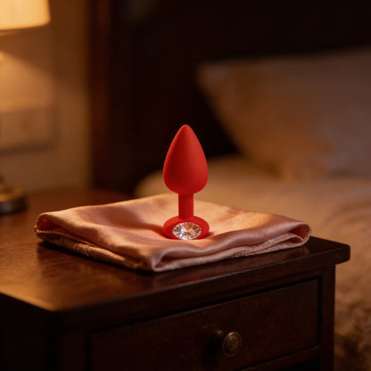 Plug bijou rouge sur une étoffe de soie, lumière chaude