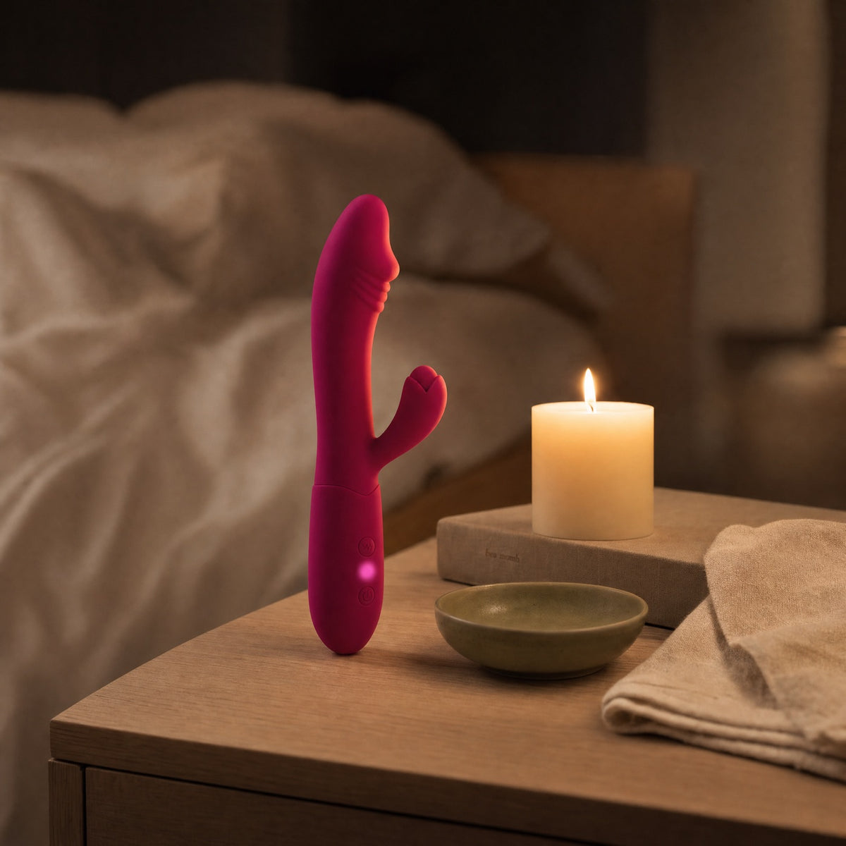 Vibromasseur rabbit rose sur une table de chevet, bougie
