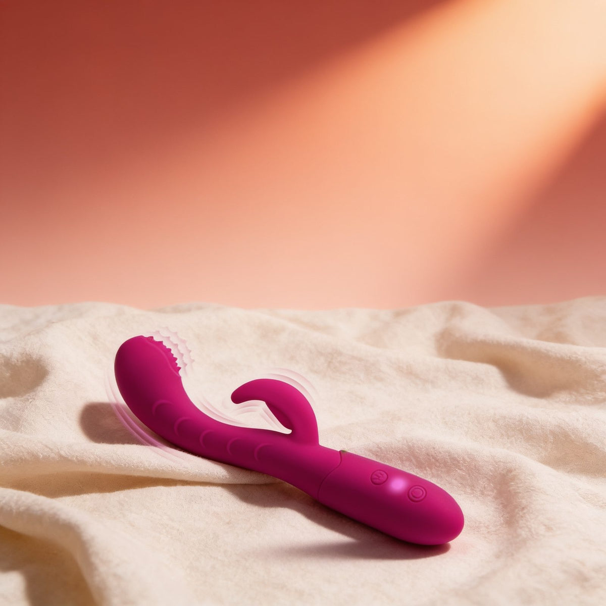 Vibromasseur rabbit USB Bess — posé sur du lin drapé, lumière chaude éditoriale